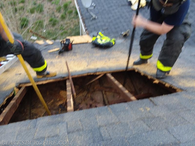 Firefighter Michael Ross and Captain Brian Falls completing the ventilation hole. 